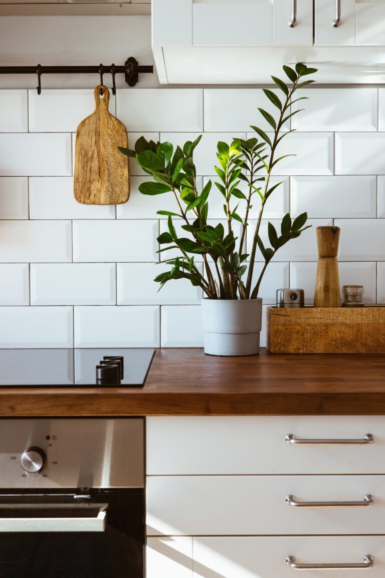 Kitchen brass utensils, chef accessories. Hanging kitchen with white tiles wall and wood