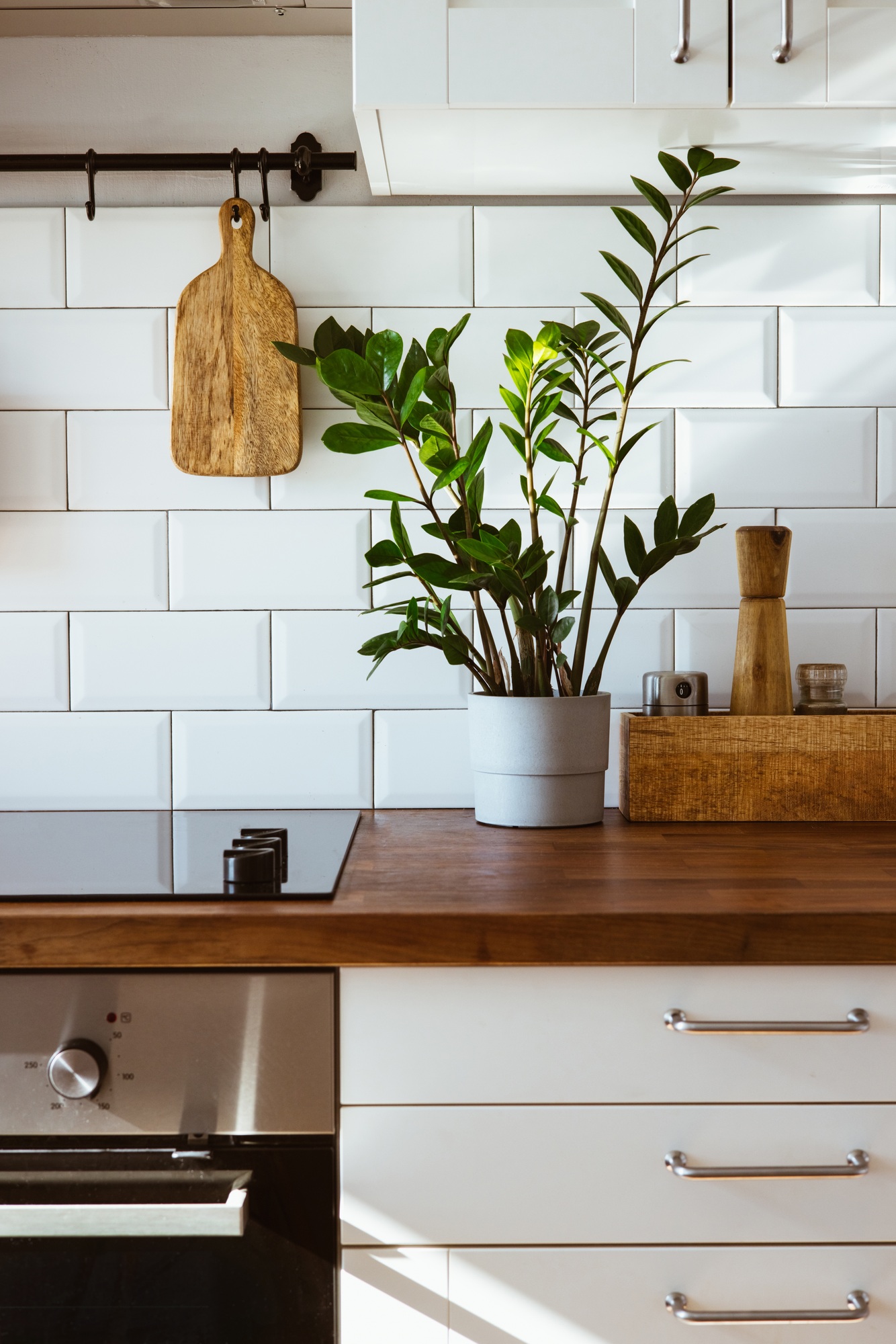 Kitchen brass utensils, chef accessories. Hanging kitchen with white tiles wall and wood